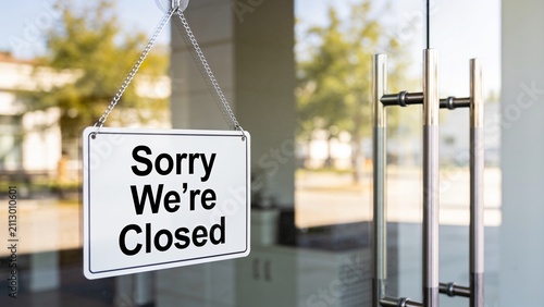 Closed business sign hanging outside modern glass storefront during daylight