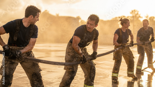 Firefighters pulling a hose in training