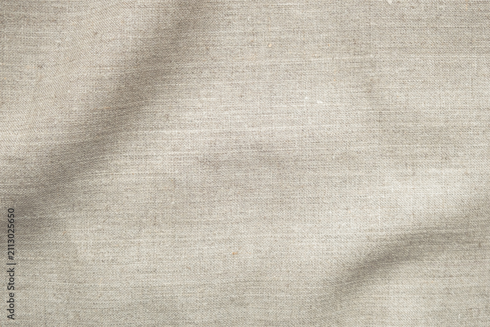 Fototapeta premium Natural beige linen fabric texture with soft shadow and copy space. Organic textile background ideal for branding, skincare, packaging, lifestyle and minimalist design.