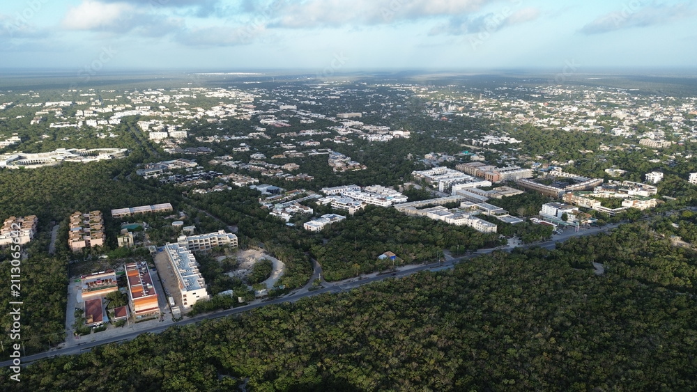 Fototapeta premium Aerial view of Tulum town expansion and residential neighborhoods surrounded by dense jungle, Mexico