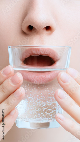 Warm salt water gargle mouth care clean hand clear glass lips nose closeup hygiene health throat care salt water water oral care skin face natural female wellness cleansing medical treatment home