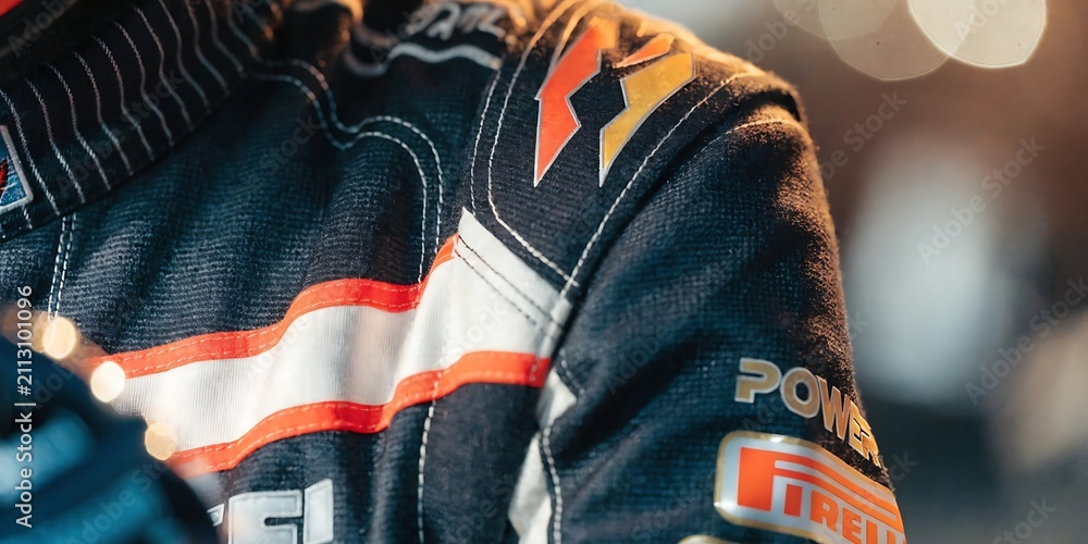 Obraz premium Detail of a professional formula one driver fireproof racing suit with sponsor logos and stitch