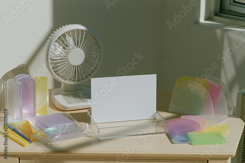 Blank white card mockup on desk with fan and clear stationery