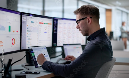 Quadro su tela Man Reviews Financial Sanctions Alerts On Laptop