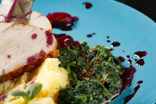 Roasted meat with mashed potatoes and spinach on blue plate potatoes culinary