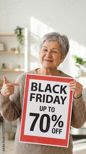 A cheerful senior woman holds a sign advertising a big holiday sale event