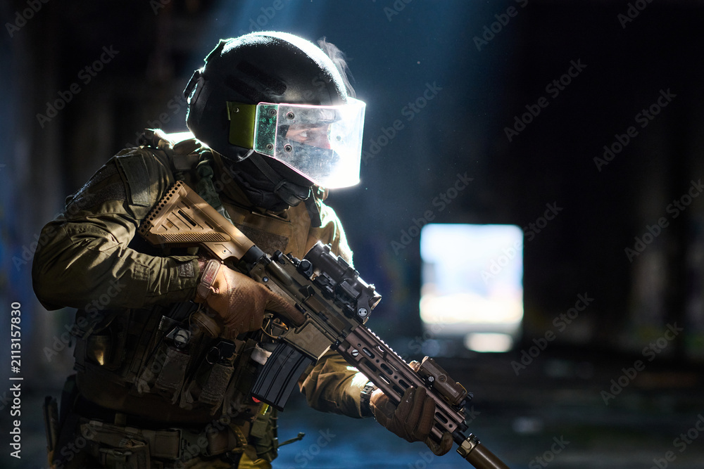 Obraz premium Armed Tactical Soldier in Ballistic Helmet With Assault Rifle During Urban Close-Quarters Operation