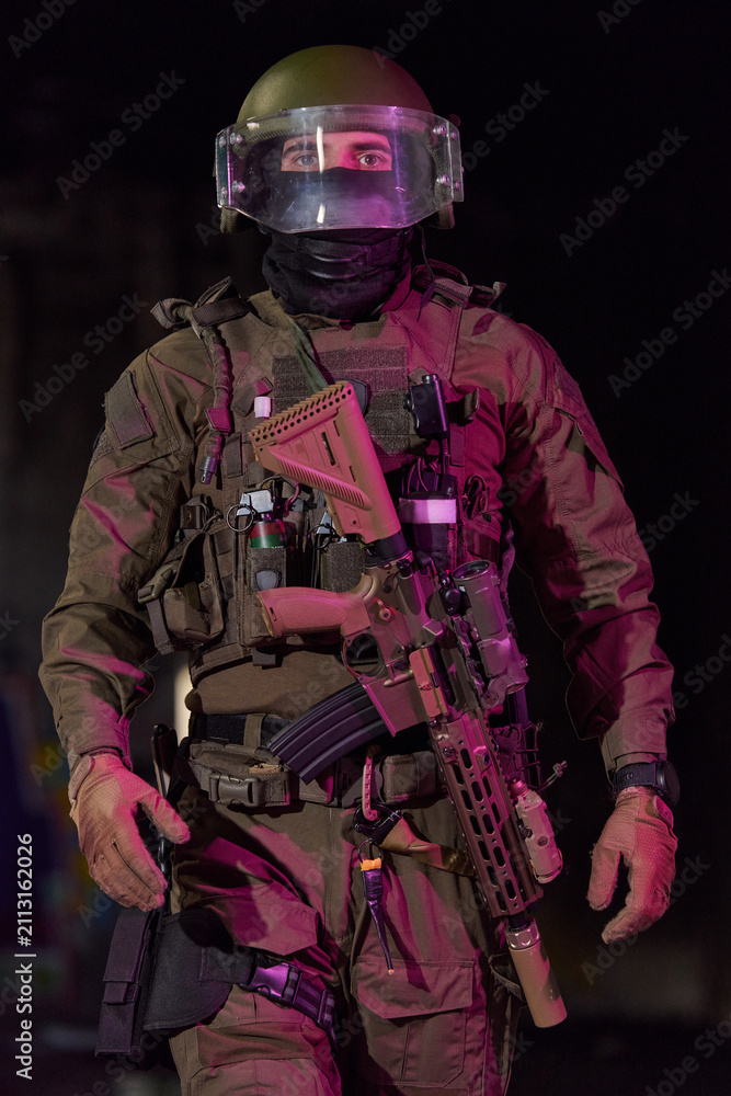Obraz premium Tactical Soldier in Full Gear With Helmet, Shield Visor and Assault Rifle at Night Patrol