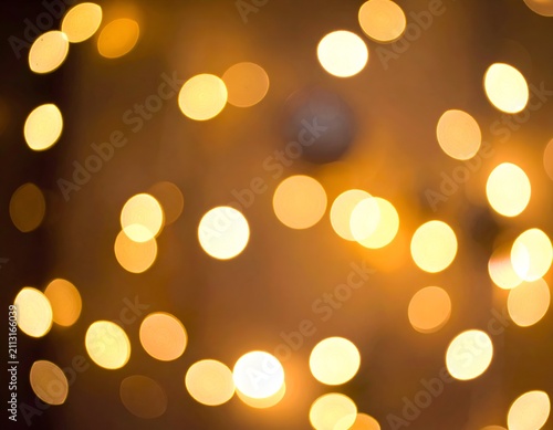 Warm, blurry golden orbs create a bokeh effect on a textured, brown background