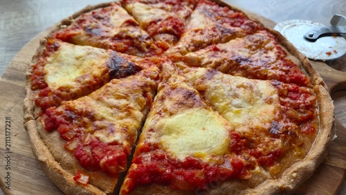 Slices of cheese pizza on a wooden board during lunchtime