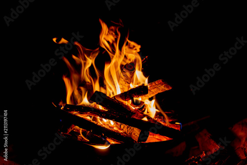 Photography Dancing campfire flames over glowing embers and burning wood on a dark night bac