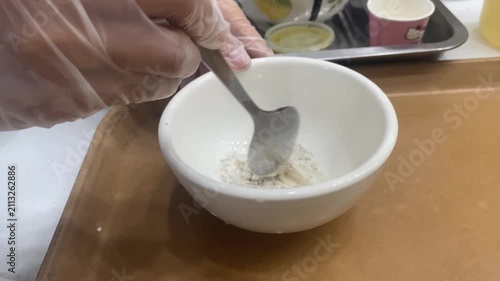 healer is preparing a herbal powder concoction on the work table.