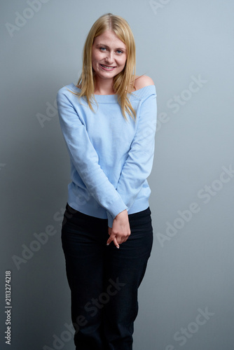 Photography Smiling Woman in Blue Sweater Against Neutral Grey Background