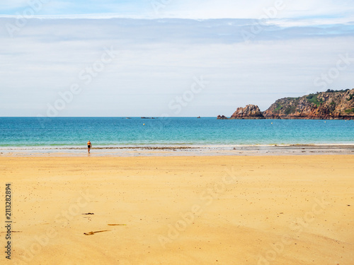 Quadro su tela A person standing on the sandy beach at Ouaisne Bay on the beautiful island of J