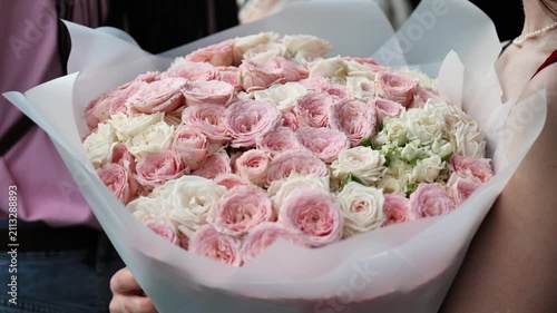 Girl holding large bouquet of pink and white roses, celebrating love and romance