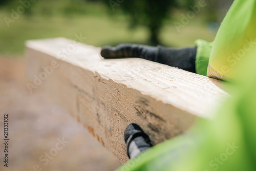 person carrying wooden material at a construction site