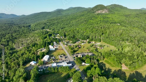 Aerial view of Elizabethtown, New York, surrounded by Adirondack Mountains, forests, and scenic countryside beneath clear summer skies.