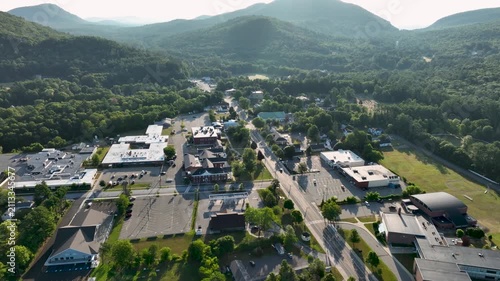 Aerial view of Court Street in Elizabethtown, New York, surrounded by forested Adirondack mountains under clear summer skies.