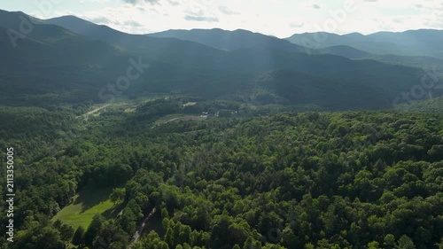 Hyperlapse aerial view of Adirondack Mountains with drifting clouds casting moving shadows across forested peaks during a tranquil summer day.