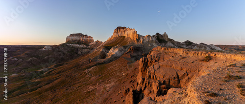 Panorama of the Airakty valley at the sunrise with waning moon in the sky, Mangystau, west Kazakhstan