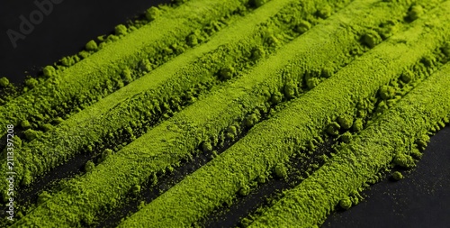 Close-up of Vibrant Green Matcha Powder Spread on Dark Surface for Culinary Use