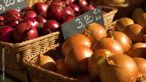 Organic onions in baskets at market stall