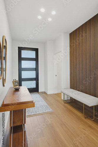 Stylish entryway with light wood flooring and white walls