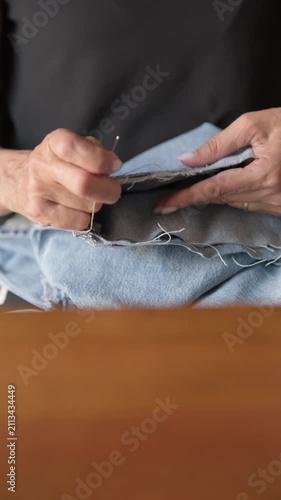 Hand sewing denim jeans hem with thimble scissors pins vertical- Rec709 Color Graded

