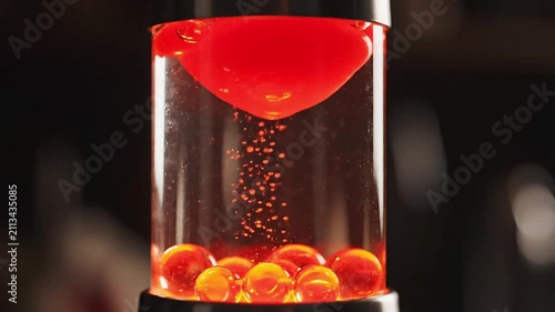Liquid motion toy featuring cascading red droplets inside a clear cylinder creates a relaxing visual effect.