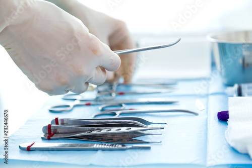 Fotografie Close Up of Surgeon Selecting Sterile Surgical Instruments Before Operation