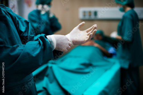 Photos Surgeon Putting on Sterile Gloves Before Surgery in Operating Room