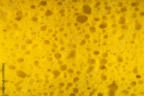 Yellow sponge texture close up. Bright yellow synthetic sponge texture