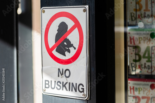 no busking sign on post outside shops