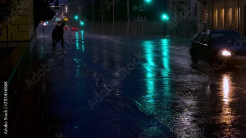 
Night city scene during heavy rain, slow motion raindrops and water streams, reflections of lights on wet asphalt, atmospheric weather and dramatic mood,