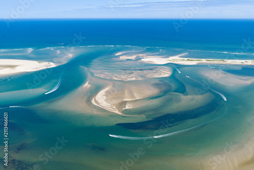 Boats cruise inside the north channel, a dynamic tidal inlet connecting Pleasant Bay, Cape Cod, MA, to the Altantic Ocean. Currents are continuously shaping the beaches, channels, and sandbars here.