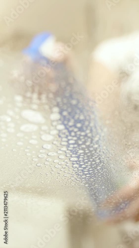 Female Person spraying glass table in slow motion