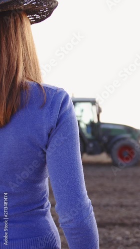 Female farmer watching over soil treatment in slow motion