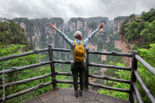 Young female tourist enjoying beautiful nature landscape with mist at Tianmen Shan national park, The famous tourist destination at Zhangjiajie