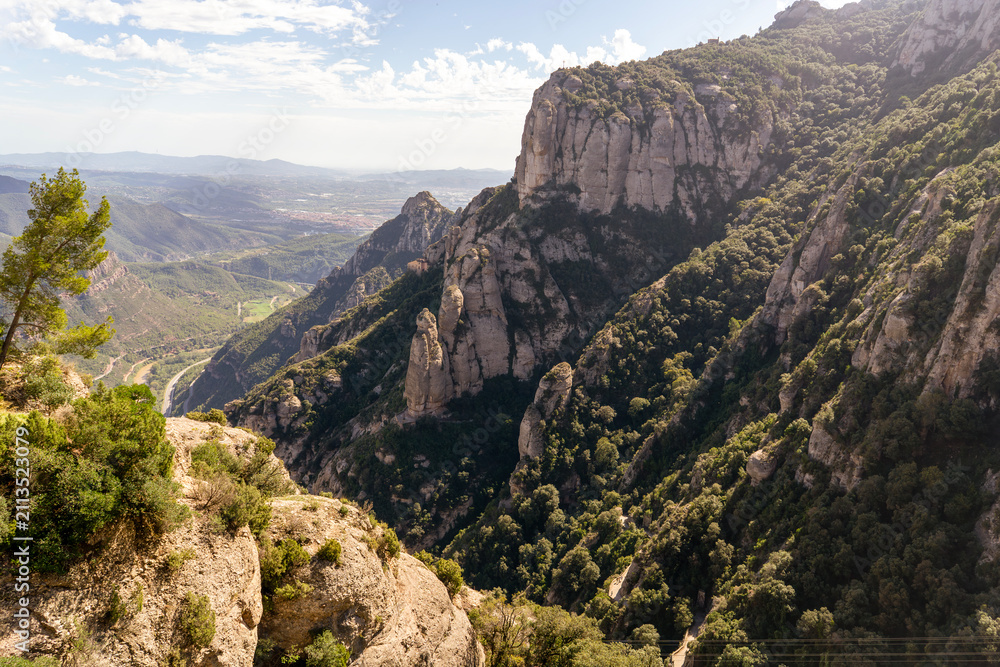 Fototapeta premium Peaks of Montserrat mountains in a rays of a sun at sunset.
