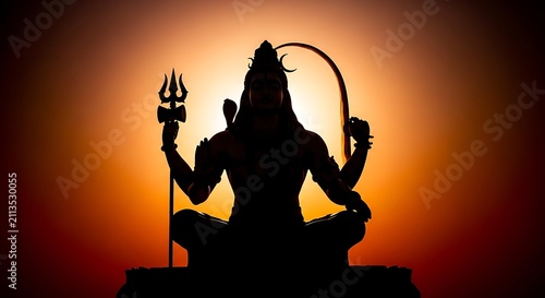 Silhouette of Lord Shiva sitting in meditation against a sunset sky