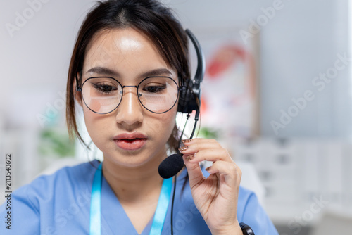 Professional women wearing headset providing telehealth support in clinic, representing virtual consultation, patient communication, healthcare service, remote care, medical assistance.