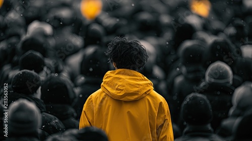 A person in a bright yellow jacket stands out from a blurred, monochrome crowd