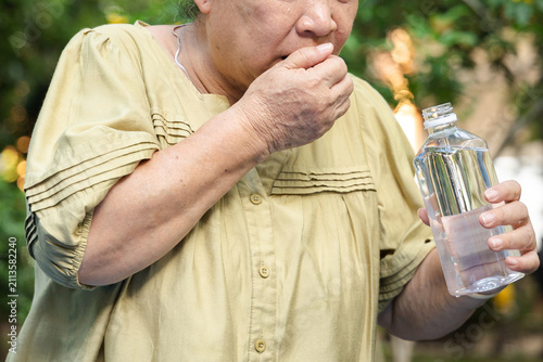 Photos elderly asian senior woman gasping and coughing after choking on bottled water o