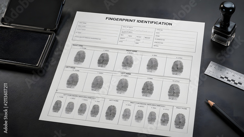 A blank fingerprint card placed on a dark gray surface next to the ink pad.