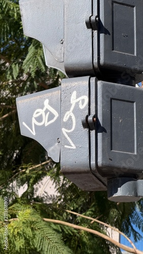 Quadro su tela Close-up of street traffic light visor with white handwritten graffiti tag