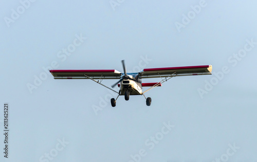 Old classic propeller airplane flying on isolated blue sky