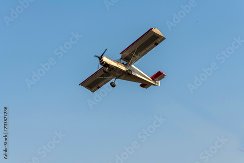 Old classic propeller airplane turning on isolated blue 