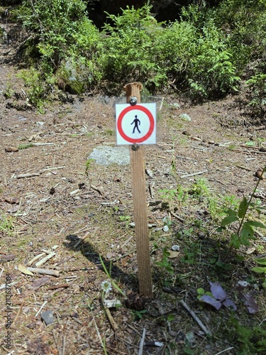 No Pedestrians Allowed Prohibitive Warning Sign on Wooden Post in Nature Reserve