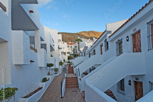 White resort apartment complex with terracotta walkway in Los Cristianos, Tenerife, Canary Islands