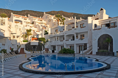 White resort hotel with swimming pool and mountain backdrop, Los Cristianos, Tenerife